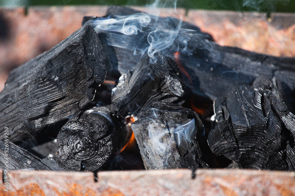 Close-up black burnt coal - smoldering firewood in the grill Close-up black burnt coal - smoldering firewood in the grill