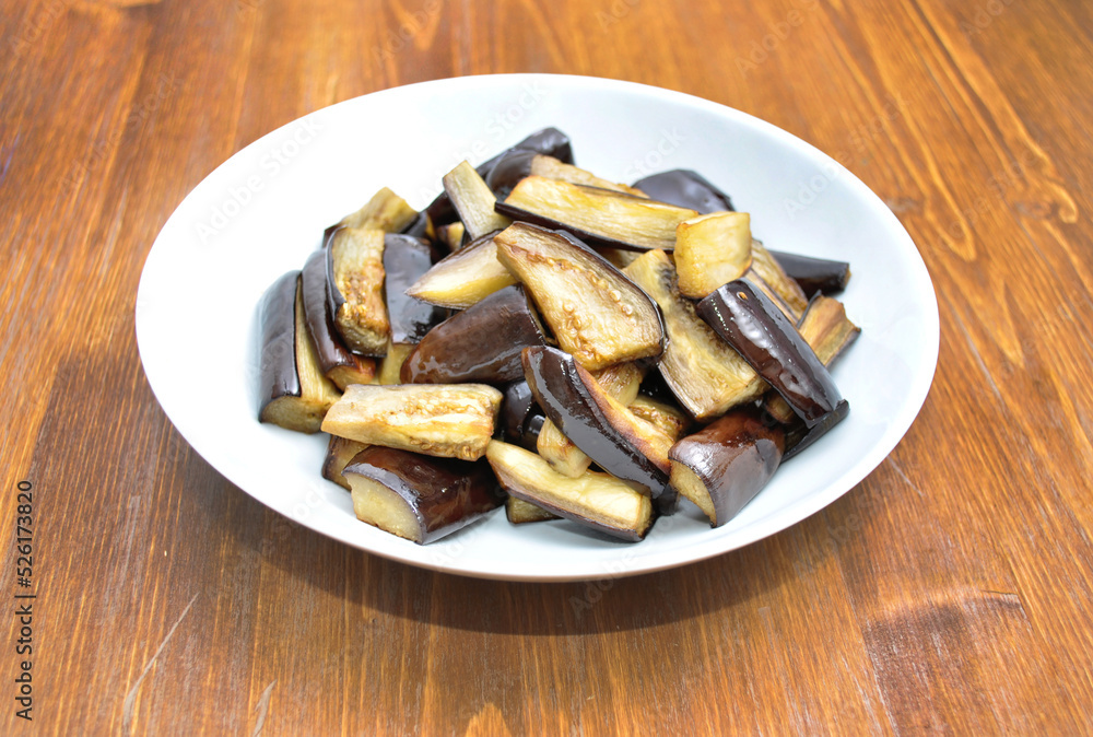 dish with baked eggplant on a wooden table dish with baked eggplant on a wooden table