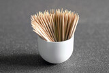 wooden toothpicks in a cup on a dark background