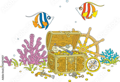 Funny tropical butterfly fishes swimming over a treasure chest full of gold coins, a pirate map and an old wooden helm with a marine compass from a sunken filibuster sailboat on a coral reef