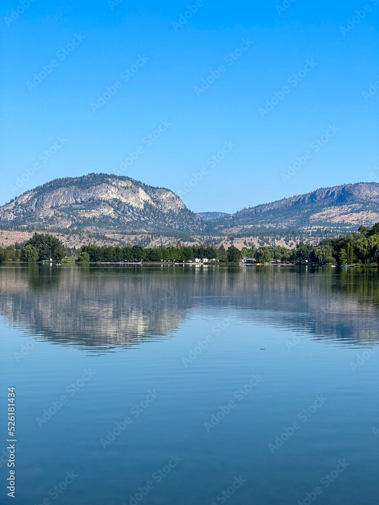 Lake and mountain view, reflection on the water, blue summer sky,  Okanagan Valley, British-Columbia, Canada