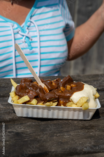 Lunch with traditional street food in Belgium, French fried potatoes with beef stew and mayonnaise photo