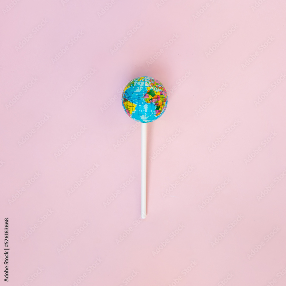 Globe lollipop on pastel light pink background. Minimalistic environment composition. Creative candy world flat lay. Beauty of the planet idea. World Earth day concept. Globe lollipop on pastel light pink background. Minimalistic environment composition. Creative candy world flat lay. Beauty of the planet idea. World Earth day concept.