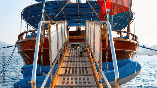 Boarding ladder for boarding tourists on a wooden yacht. Beach slippers taken off at the entrance to the ship.
