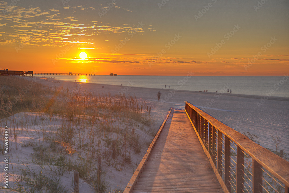 Boardwalk to the Sunrise Gulf Shores Public Beach  101 Gulf Shores Pkwy. Gulf Shores Alabama   Photo taken on September 27, 2021    A boardwalk leads to the beach and the rising sun. 
