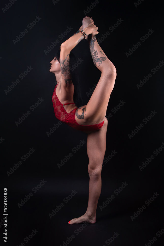 Photo of gymnast girl with tattoo stretching in red lingerie