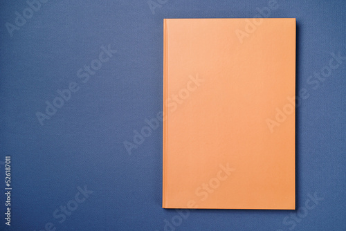 Orange Leather notebook on paper intense blue background, notepad mock up, top view shot