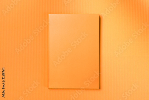 Orange Leather notebook on paper orange background, notepad mock up, top view shot