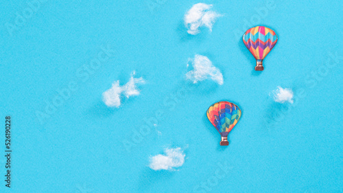 Flight of balloons in the clouds, blue background with space for text
