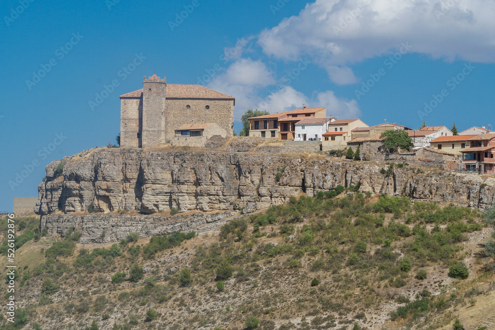 Vista panorámica de Moscardón al borde de un barranco en Teruel con su Iglesia de San Pedro  Apóstol  sobresaliendo sobre la población