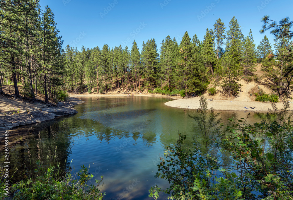 The small bay and sandy beach at Black Bay Park in the rural town of Post Falls, Idaho, near Coeur d'Alene, Idaho, along the Spokane River. The small bay and sandy beach at Black Bay Park in the rural town of Post Falls, Idaho, near Coeur d'Alene, Idaho, along the Spokane River.