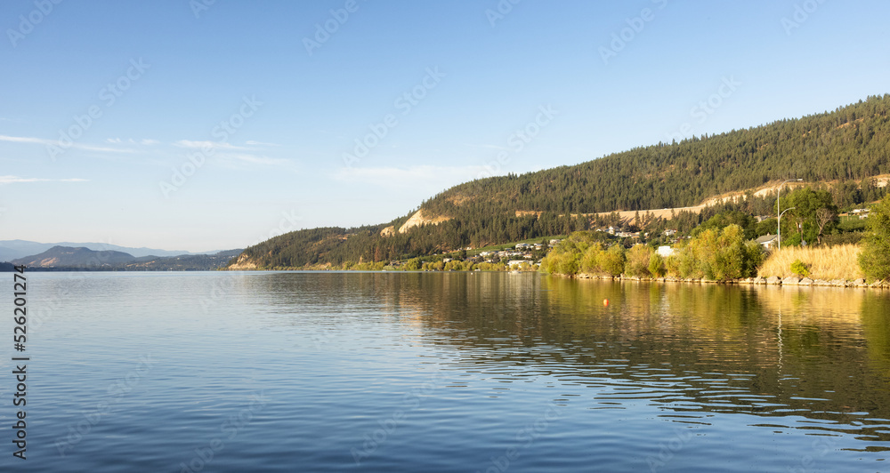 Peaceful View of Wood Lake with Reflection on the water and mountains in background. Lake Country, Okanagan, British Columbia, Canada. Sunrise