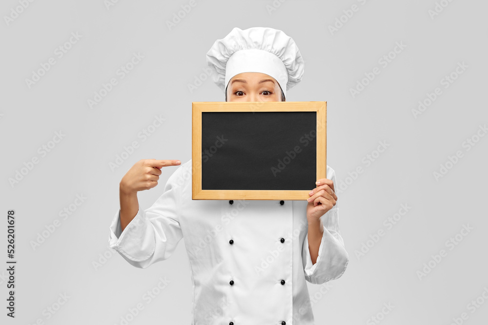 cooking, advertisement and people concept - female chef holding black chalkboard over grey background cooking, advertisement and people concept - female chef holding black chalkboard over grey background