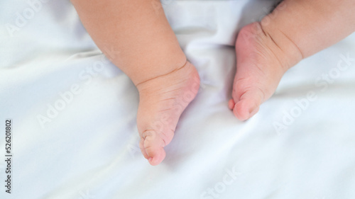 Newborn chubby legs and foots. Beautiful conceptual image of motherhood and baby
