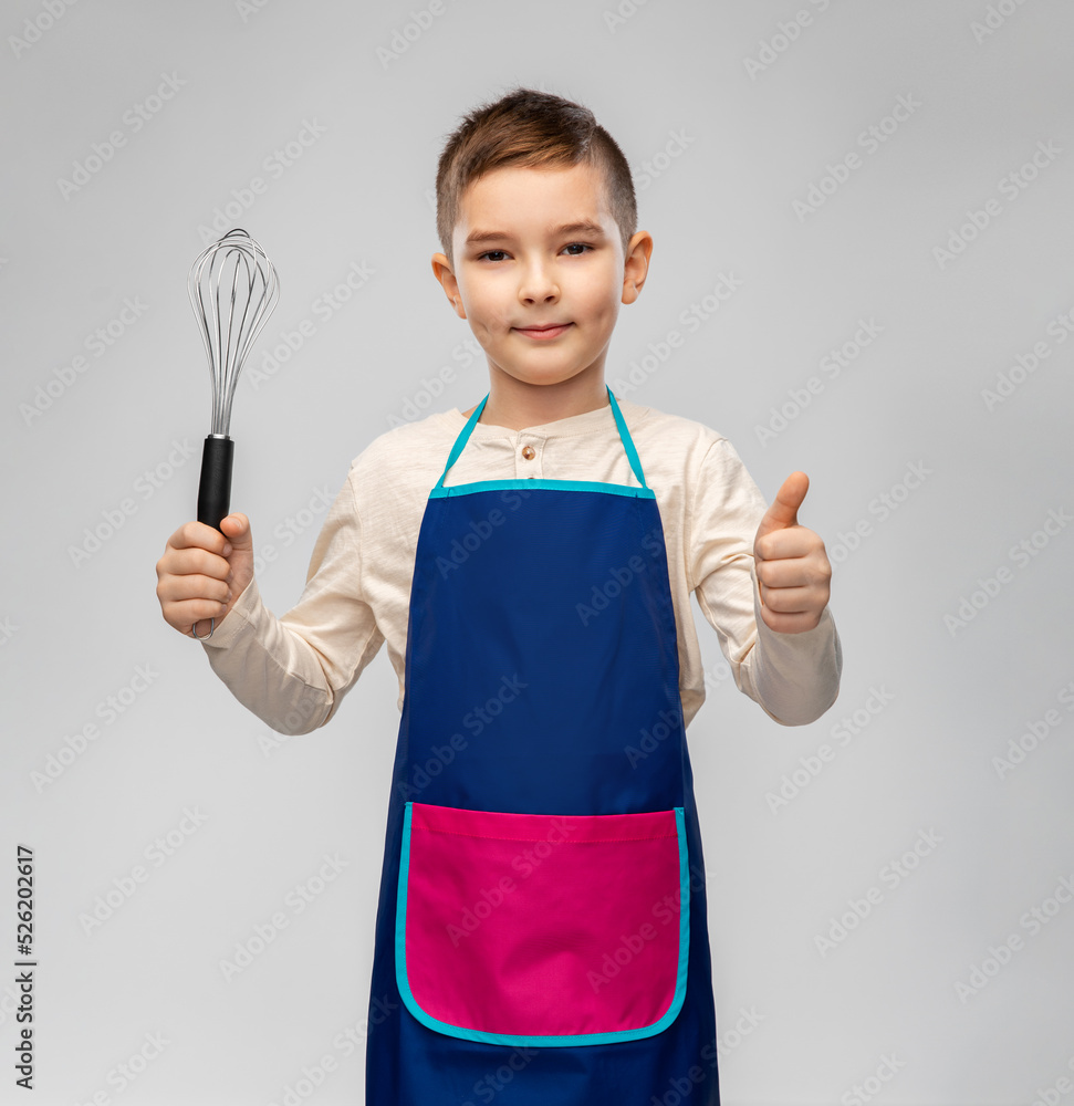 cooking, culinary and profession concept - happy smiling little boy in apron holding whisk showing thumbs up over grey background cooking, culinary and profession concept - happy smiling little boy in apron holding whisk showing thumbs up over grey background