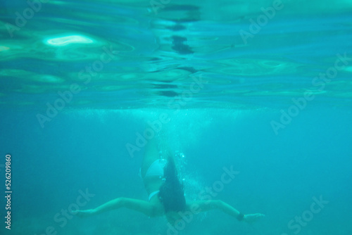 Beautiful woman swimming underwater on paradise beach freedom wellbeing lifestyle summer vacation wanderlust © Moose/peopleimages.com