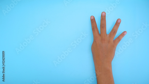 Male hand showing hand four sign isolated on blue background 