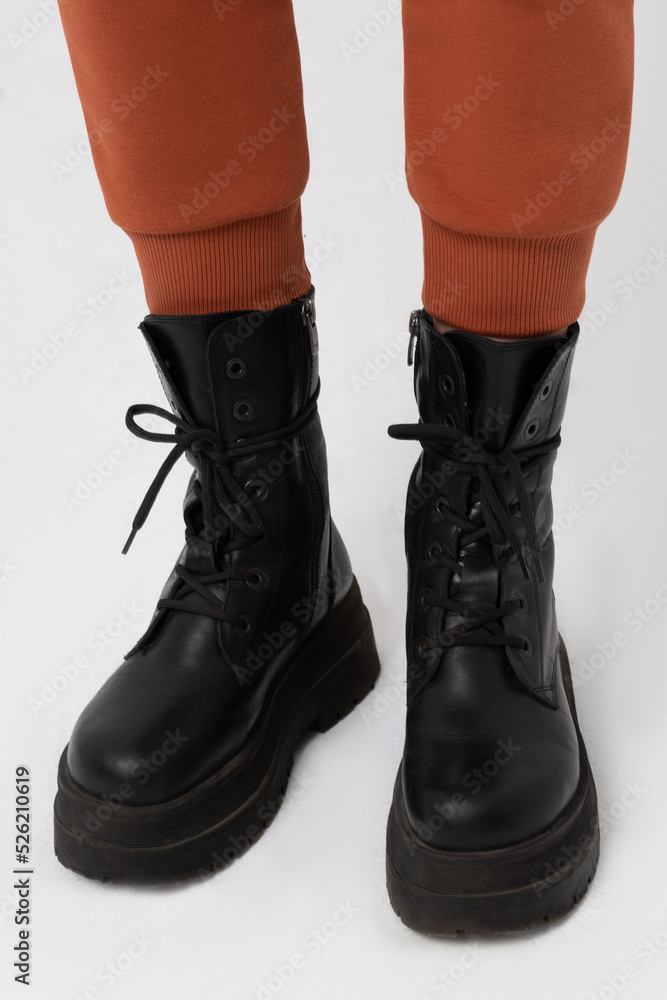 A man, male, boy wearing military shoes, combat military boots and cargo pants at the studio. A man, male, boy wearing military shoes, combat military boots and cargo pants at the studio.