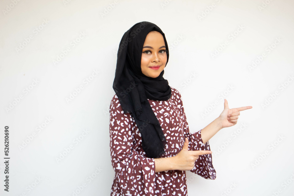 Asian hijab young woman isolated on white background smiling while pointing with two hands to copy space for ad Asian hijab young woman isolated on white background smiling while pointing with two hands to copy space for ad