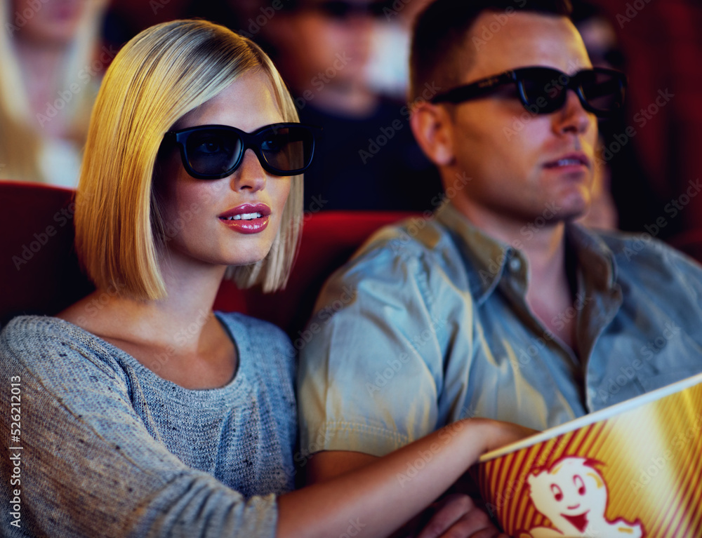 Obraz premium Couple, 3D movie and cinema of a man and woman sitting and eating popcorn together wearing glasses. People in a relationship watching a film in a theatre for indoor entertainment while having snacks.