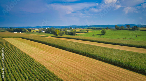 Drone View of Amish Countryside With Barns and Silos and Corn, Patch Work of Color and Corps, on Sunny Day. © Greg Kelton