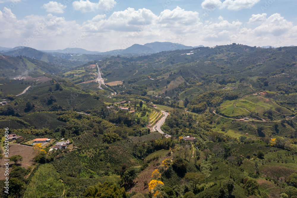 Aerial view of highway between mountains and agricultural fields. Colombia.