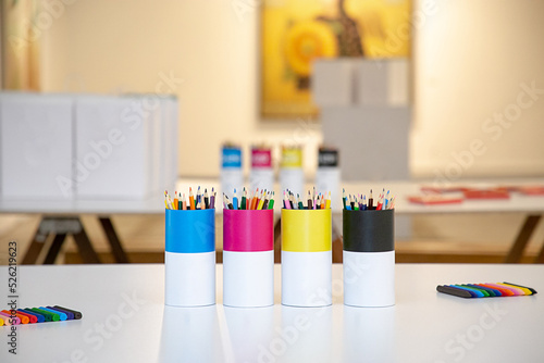 Colores y lápices en escritorio en envases editables, útiles escolares, concepto de talleres y regreso al colegio. photo