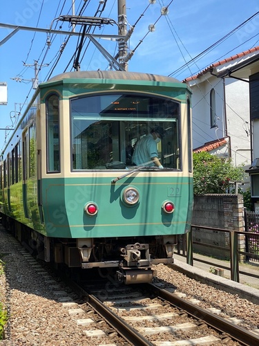 Local train from Kamakura to Enoshima in Japan, passing by houses closely 