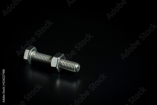 Bolt and nut isolated on a black background with space for text.
