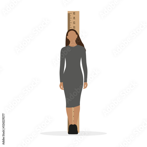 Young woman stands in front of a large ruler on a white background