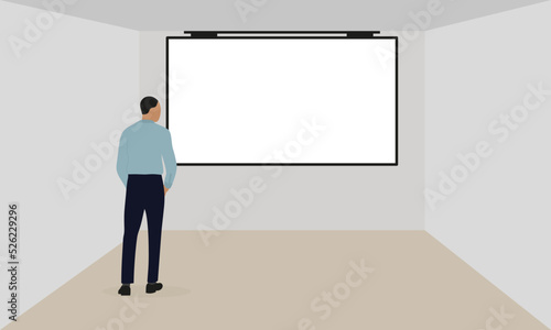 A man in business clothes stands in front of a blank screen hanging on the wall