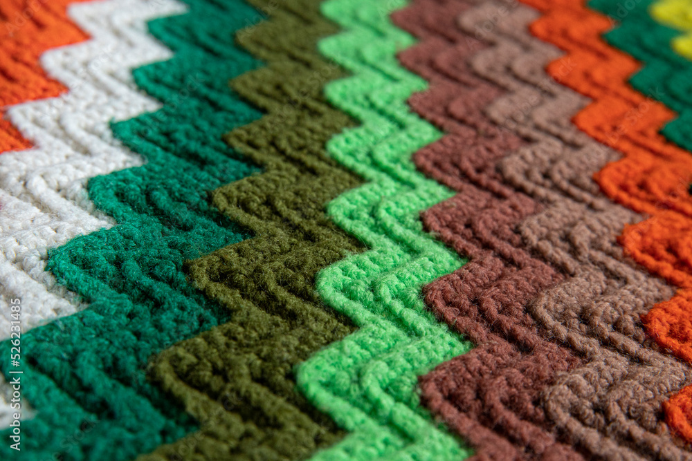 Fototapeta premium close-up of grandma's retro zigzag striped blanket, crocheted or knitted, grandma's house, cozy and warm