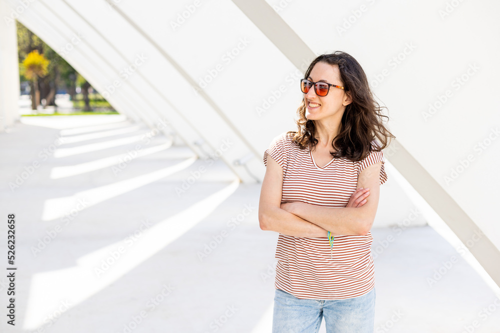 Smiling girl in sunglasses is walking at street of city Smiling girl in sunglasses is walking at street of city