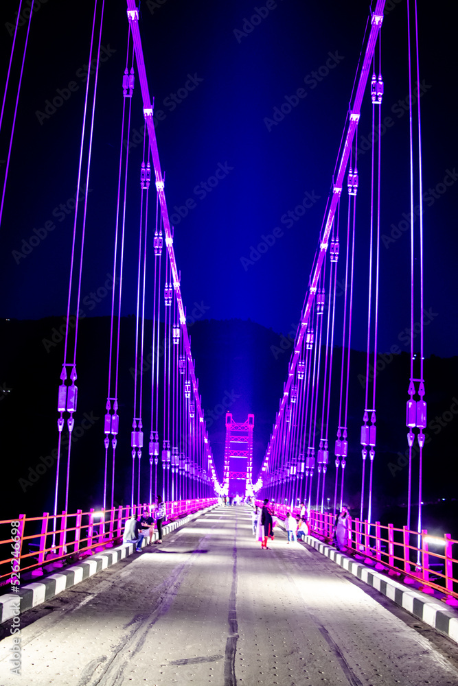 Obraz premium Colourful Dobra Chanti hanging bridge over Tehri Lake. Night view of Dobra-Chanti bridge. The 725-metre long Dobra Chanti suspension bridge over the Tehri lake. 