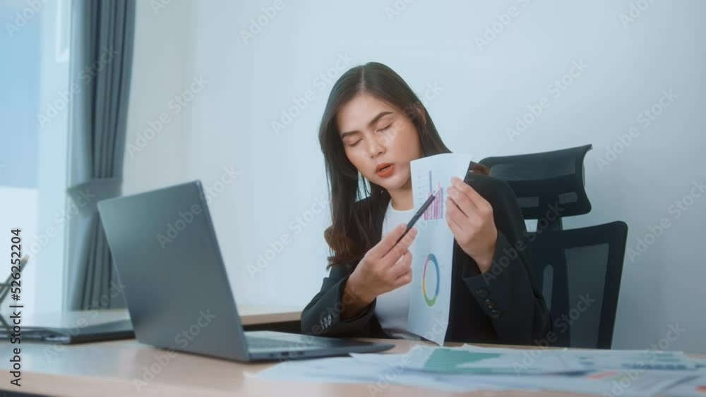 Young beautiful business woman working on laptop with documents in modern office Young beautiful business woman working on laptop with documents in modern office