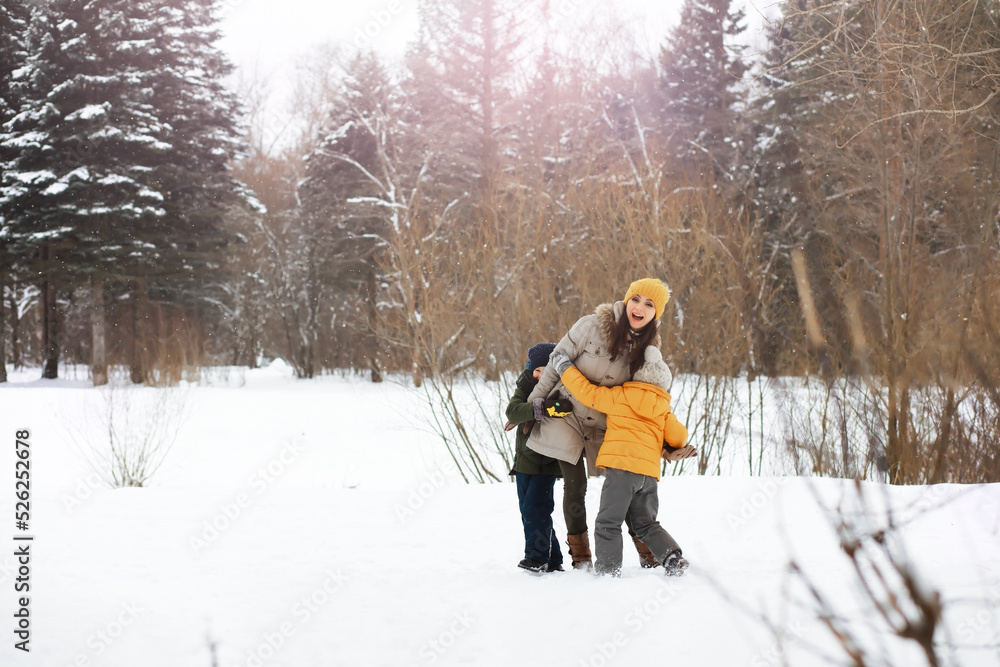 Happy family playing and laughing in winter outdoors in the snow. City park winter day.