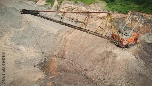 Huge dragliner excavator mining gold in an open pit. Aerial industrial quarry scene. Mining precious minerals. Pollution, environment and ecology concept photo