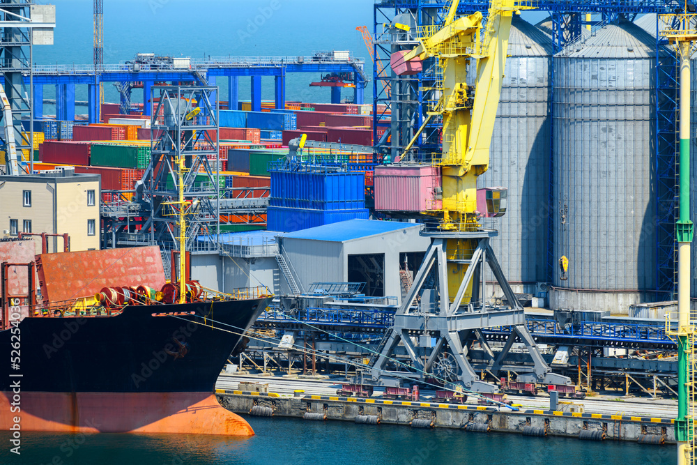 industrial seaport infrastructure, sea, cranes and dry cargo ship, grain silo, bulk carrier vessel and grain storage elevators, concept of sea cargo transportation industrial seaport infrastructure, sea, cranes and dry cargo ship, grain silo, bulk carrier vessel and grain storage elevators, concept of sea cargo transportation