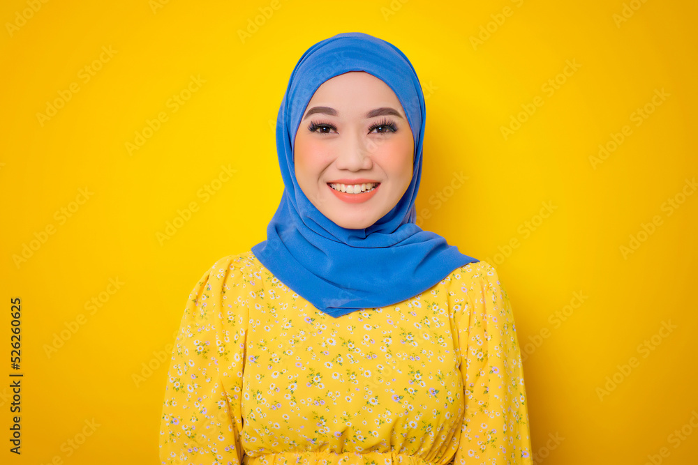 Close up of smiling young Asian woman in casual dress looking confident and relaxed isolated on yellow background Close up of smiling young Asian woman in casual dress looking confident and relaxed isolated on yellow background