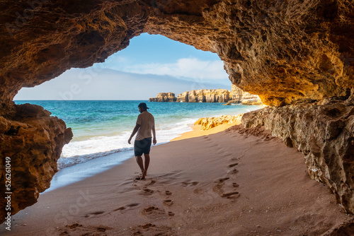 A man in the beach cave at Praia da Coelha, Algarve, Albufeira. Portugal