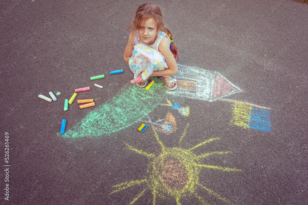 Naklejka premium Child from Ukraine draws with chalk.