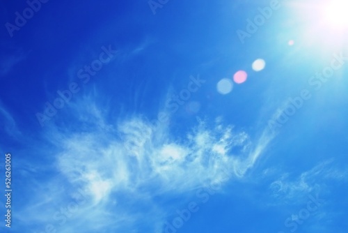 Nubes disipándose en la altura con el cielo azul. Sol iluminando el cielo en un brillante y frío día de invierno al mediodía.