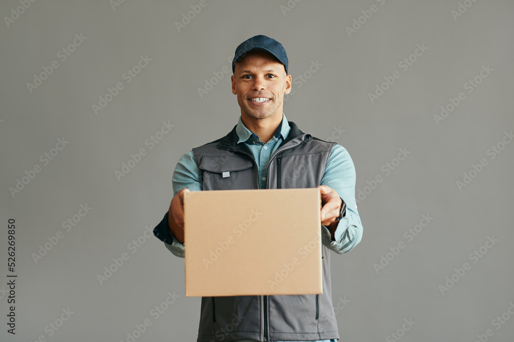 Happy African American delivery man with package looking at camera. Happy African American delivery man with package looking at camera.