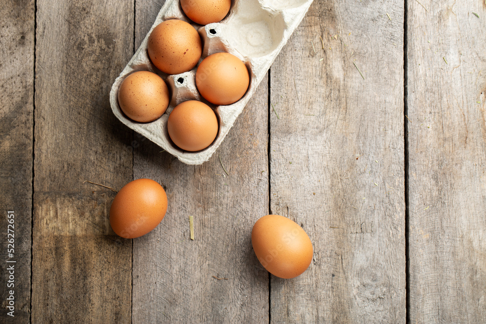 Fresh organic chicken eggs in carton or egg container on wood background. Farming and farming concept. Fresh organic chicken eggs in carton or egg container on wood background. Farming and farming concept.