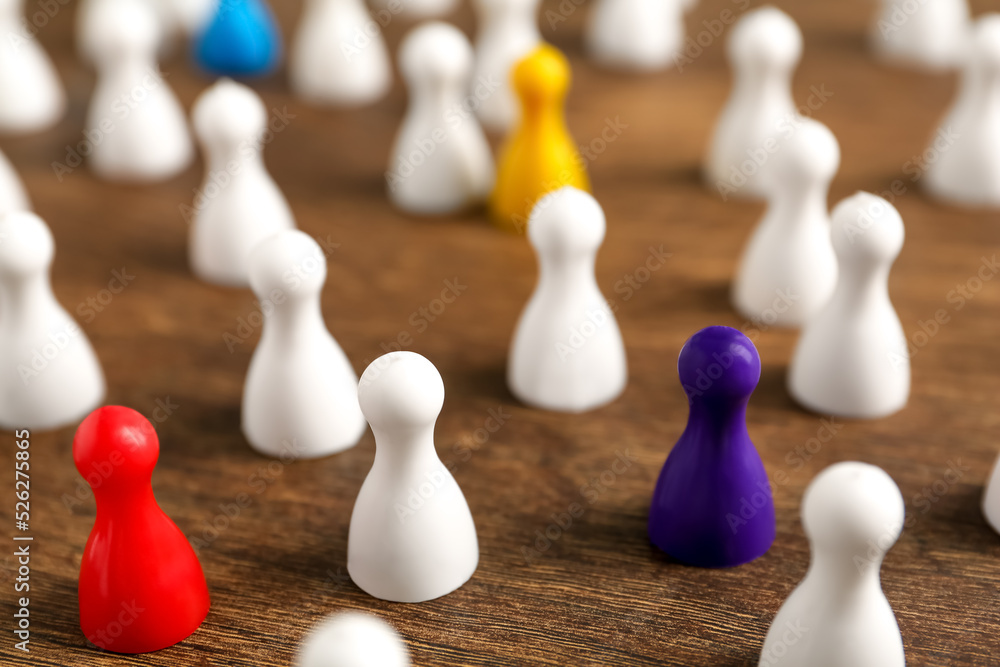 Colorful pawns on wooden table, closeup. Social inclusion concept Colorful pawns on wooden table, closeup. Social inclusion concept