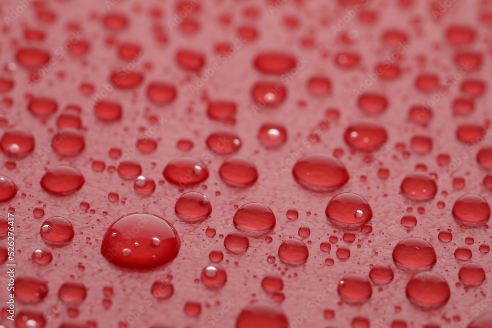 Water drops on red background, closeup view Water drops on red background, closeup view