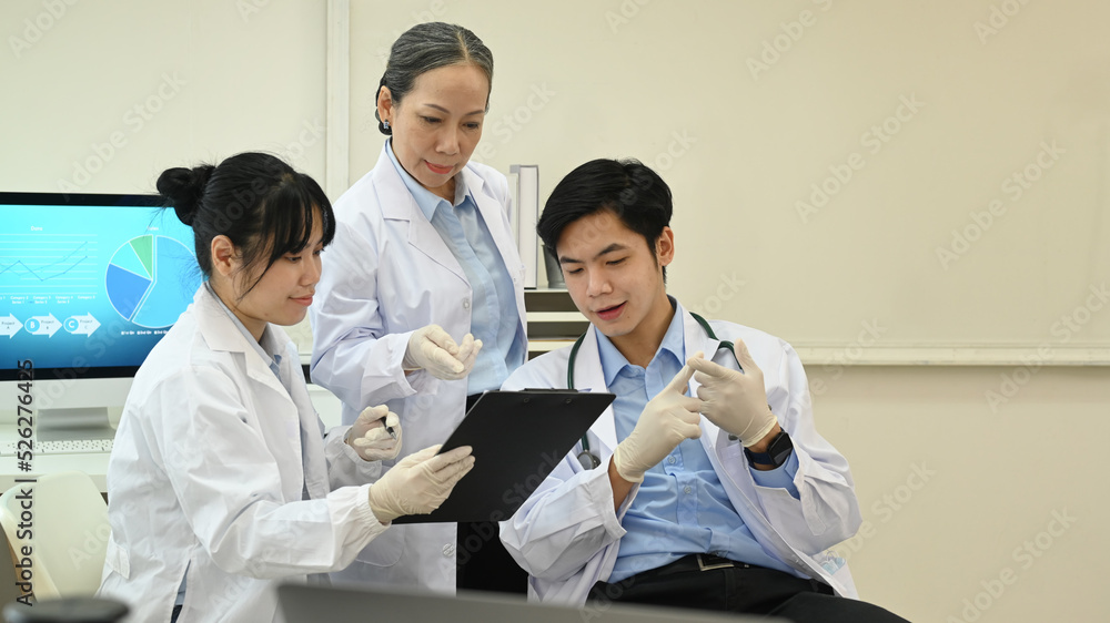 Young research scientist and senior female supervisor analyzing test samples, discussing about new test results in science laboratory Young research scientist and senior female supervisor analyzing test samples, discussing about new test results in science laboratory