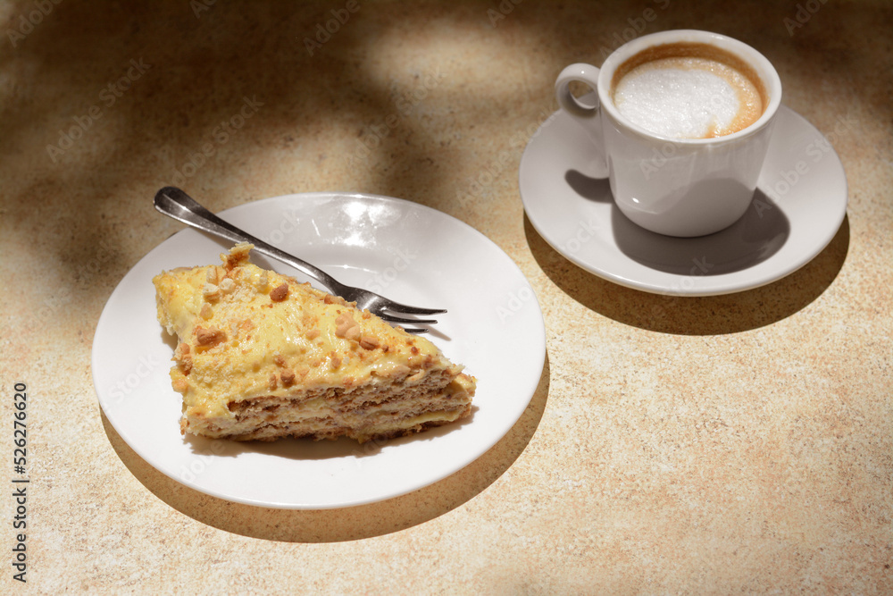 Piece of delicious cake and coffee on beige table Piece of delicious cake and coffee on beige table