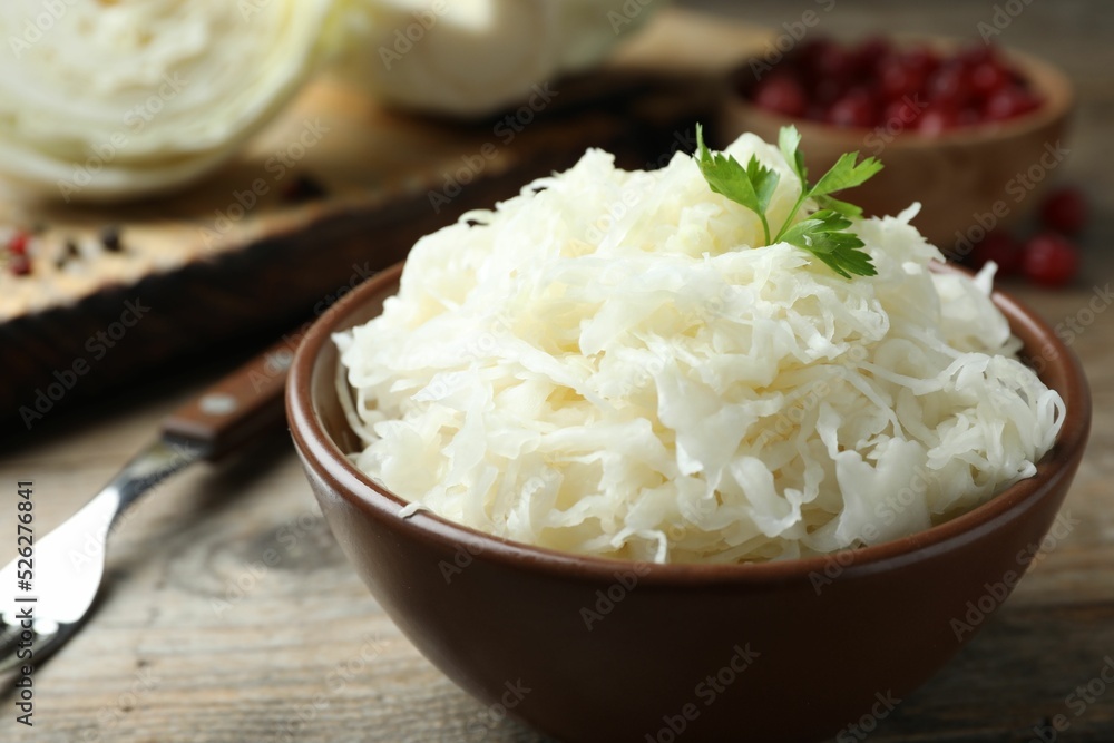 Tasty fermented cabbage on wooden table, closeup Tasty fermented cabbage on wooden table, closeup
