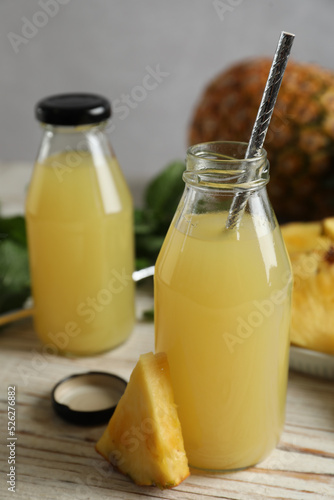 Delicious pineapple juice and fresh fruit on white table